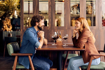 Couple Enjoying a Romantic Date at a Cozy Restaurant with Wine