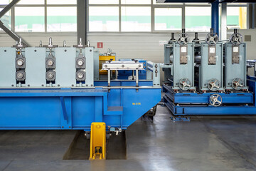 Part of a coil slitting or cut-to-length or roll forming line. A machine that form flat coil metal into shaped profiles.