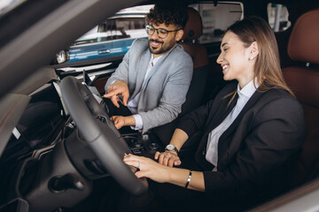 Smiling couple buying car in auto dealership