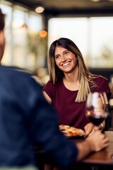 Smiling Woman Enjoying a Conversation at a Cozy Restaurant