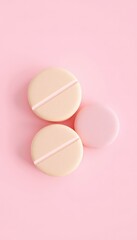 Fototapeta premium Three Pastel Colored Pill Shaped Objects on a Light Pink Background, Two of Which Have Indentations