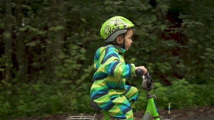 A small child, safely protected by a helmet, experiences the excitement of their first bike ride. Highlights active family life and the importance of safety in sports.