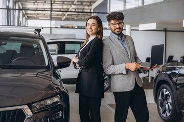 Diverse sales team posing in modern car dealership