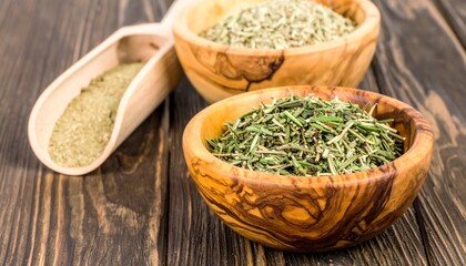 Dried herbs in wooden bowls on a dark wooden surface