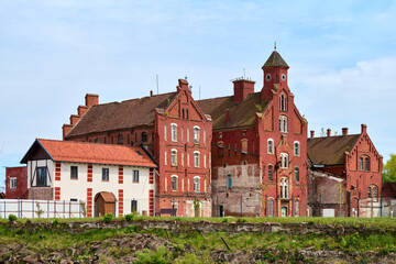 Historic red brick castle in Gvardeysk under blue sky
