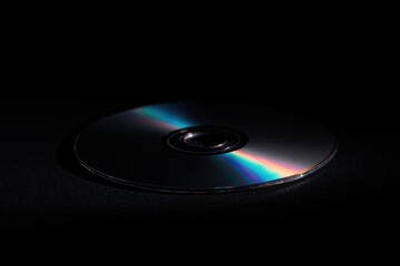 Shimmering disc reflecting light against dark backdrop evokes no