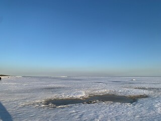Winter landscape with frozen snowy lake and clear blue sunset sky. Perfect for calendars, wall art, and seasonal designs.

