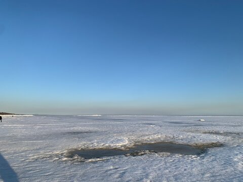 Winter landscape with frozen snowy lake and clear blue sunset sky. Perfect for calendars, wall art, and seasonal designs.

