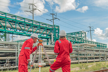 Construction workers using surveying equipment outdoors