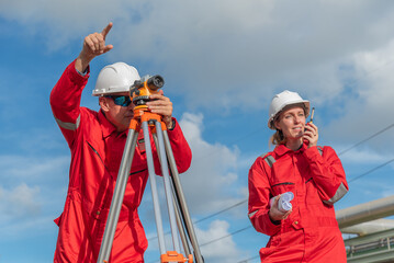 Construction workers using surveying equipment outdoors