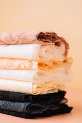 Stack of lace fabrics in pastel colors, vertical