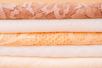 Stack of pastel lace fabrics, closeup layers