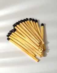 Matches in a pile on a white surface