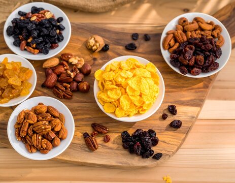 Assorted dried fruits and nuts on a wooden board - Powered by Adobe