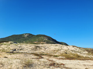 View of the mountainous coast at Santinho beach in Florianópolis, Santa Catarina, with dunes and sandbanks in a restinga area near the sea, Morro dos Ingleses.