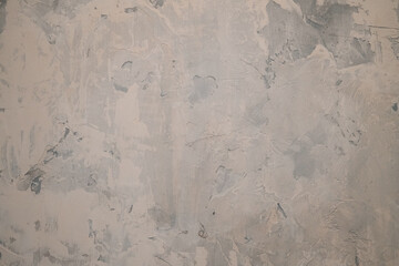 Detailed view of a textured plaster wall featuring neutral and gray hues, ideal for background use. The abstract patterns create an artistic and modern appearance.