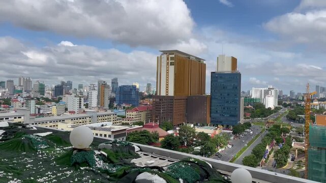 Panoramic view of Phnom Penh city skyline in Cambodia. Mix of modern skyscrapers, hotels, and urban architecture under dramatic clouds, showcasing the rapid development and vibrant atmosphere
