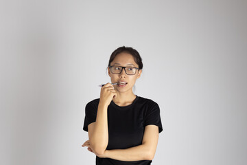 Woman in glasses standing, hand on chin