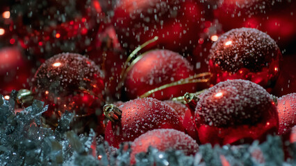 Obraz premium Christmas scene with snow falling on red tree balls decorations, close up shot. Happy New Year concept.