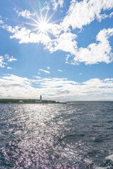 Cove Island Lighthouse stands tall, guiding ships with its historic charm amidst Ontario's stunning coastal beauty on a bright, sunlit day.