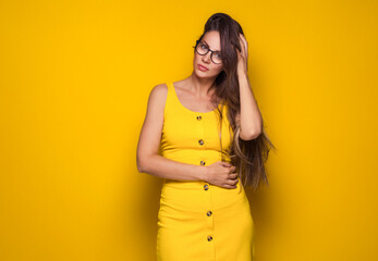Sensuality young woman posing, isolated on yellow background. Beautiful young adult lady wears...
