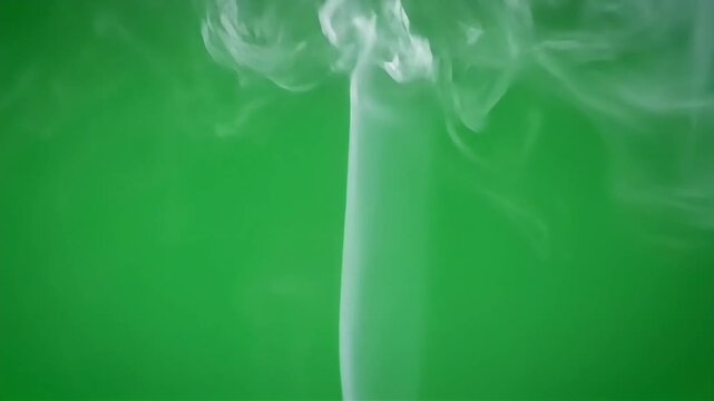Wispy white smoke gracefully rising against a vibrant green background, creating a sense of lightness and movement.