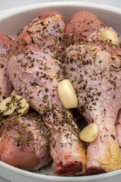 Chicken drumsticks marinated with garlic and herbs ready for cooking in a kitchen setting