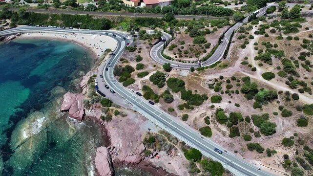 aerial view,  flying along Agay Bay coastline, French Riviera (C&ocirc;te d'Azur) with "Plage du Pourrousset"  near Village Cap Est&eacute;rel in Saint-Rapha&euml;l, with cars driving on the costal road - 4k footage 