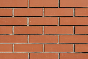 Obraz premium Orange brick wall texture with mortar lines, seamless architectural background for construction and design with copy space.