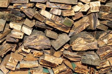 Stack of firewood logs with cut wooden texture. Rustic pile of chopped timber. Close up photography. Natural material and wood industry concept for design, poster, wallpaper, and banner