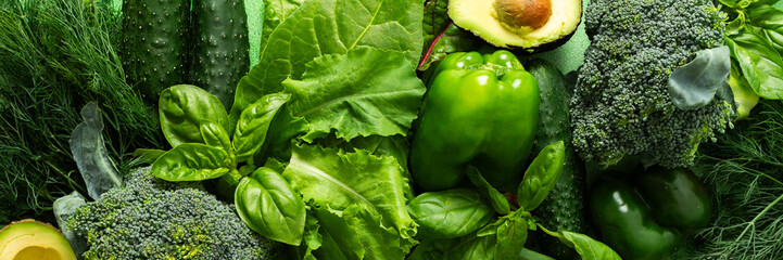 A vibrant collection of fresh green vegetables and herbs fills the scene, showcasing broccoli,...