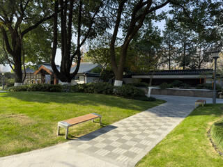 Tranquil Park Pathway Surrounded by Lush Greenery and Architectural Beauty