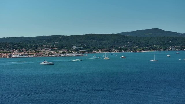 right panning along "Golfe de Saint-Tropez" coastline on French Riviera (C&ocirc;te d&rsquo;Azur) from Port of Saint-Tropez, Gassin to Grimaud with wooded hilly landscape in background - 4k aerial video footage 