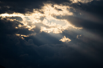 Sun light and rays breaking through thick storm clouds