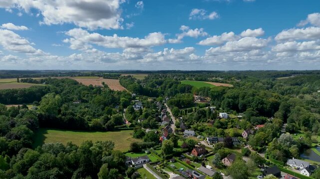 Aerial view of Genappe municipality and city of Wallonia located in the Belgian province of Walloon Brabant. Villas with garden surrounded by forest.