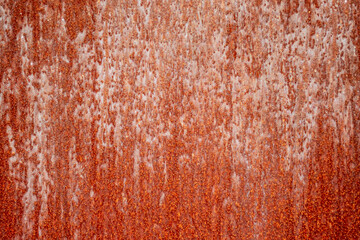 Rust on black painted metal due to environmental influences.