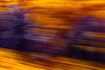 Dynamic motion blur view from high-speed train window: Green landscape, trees & fields rush past at high speed