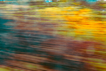 Dynamic motion blur view from high-speed train window: Green landscape, trees & fields rush past at high speed