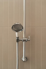 Fototapeta premium Modern shower head in elegant hotel bathroom with chic tiled walls