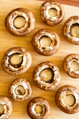 fresh champignon mushrooms on wooden cutting board close up