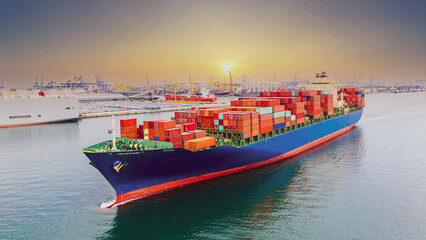 Fototapeta premium Aerial view of international cargo containers ship at industrial import-export port prepare to load containers with big container loader ship vessel at night. global transportation, logistic business