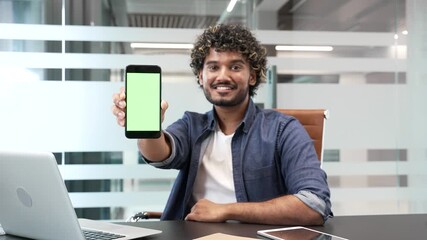 Happy businessman showing mobile phone with green screen and thumb up sitting in business office. Color key, vertical template layout for advertising. Smiling male looking at camera holding smartphone - Powered by Adobe