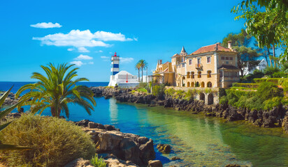 Obraz premium Beautiful look to lighthouse Farol de Santa Marta. Lighthouse in Cascais - Portugal. Amazing landscape of bay in Sintra. Nice traveling location. Wallpaper of coast and sea. Honeymoon concept