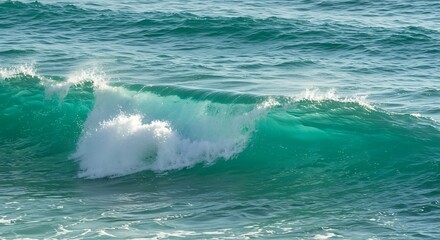 A dynamic ocean wave breaking with turquoise water and white foam.
