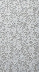 Delicate white lace fabric showcases a repeating pattern of intricate floral designs.