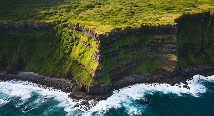 Aerial view of rugged coastal cliffs with lush green vegetation and crashing ocean waves