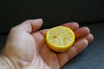 Hand Holding Half Lemon on White Background