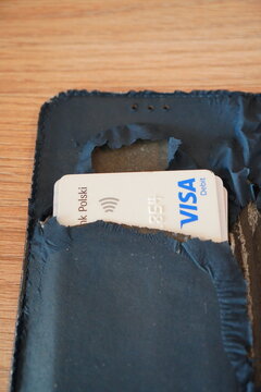 Visa card partially inserted in a torn wallet