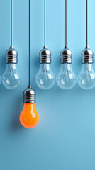 Orange light bulb glowing among transparent bulbs symbolizing creativity and innovation. 
