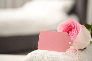 Blank card and rose on towel indoors, closeup. Space for text